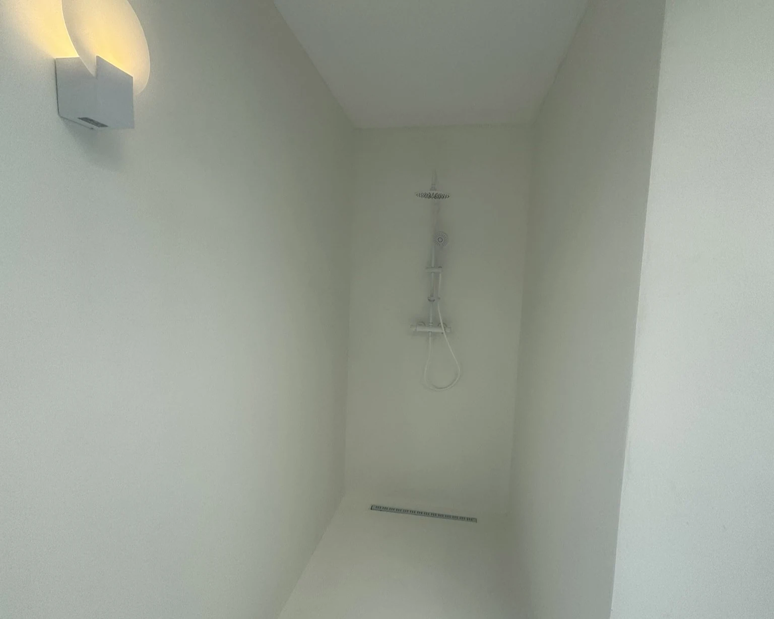 Baño completo con microcemento en paredes y ducha walk-in impermeable