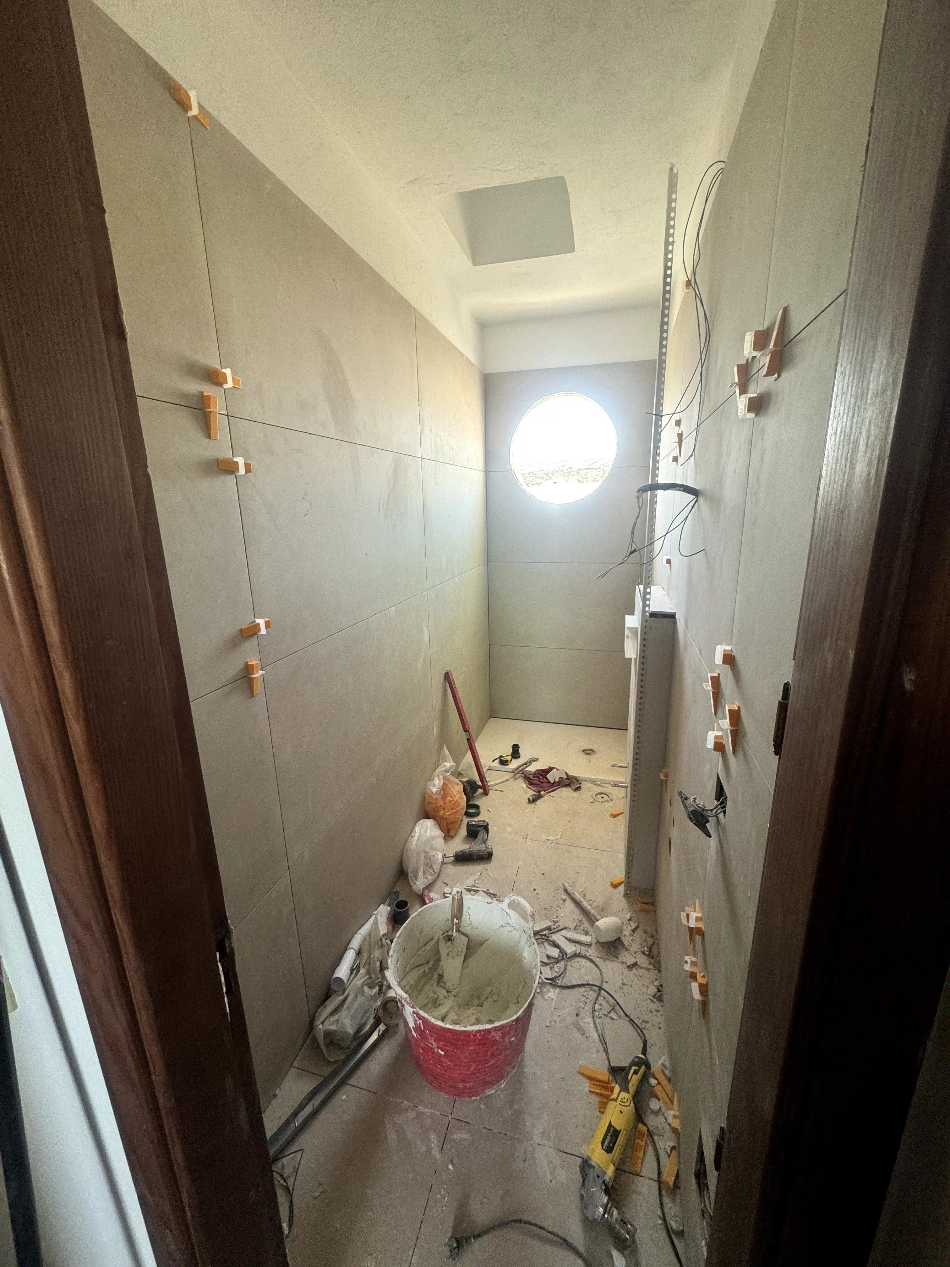 Proceso de instalación de porcelanato rectificado beige 60x60 en paredes del baño